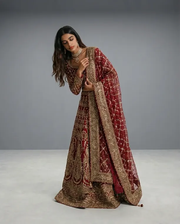 AI fashion model wearing a red embroidered bridal lehenga in a grey studio